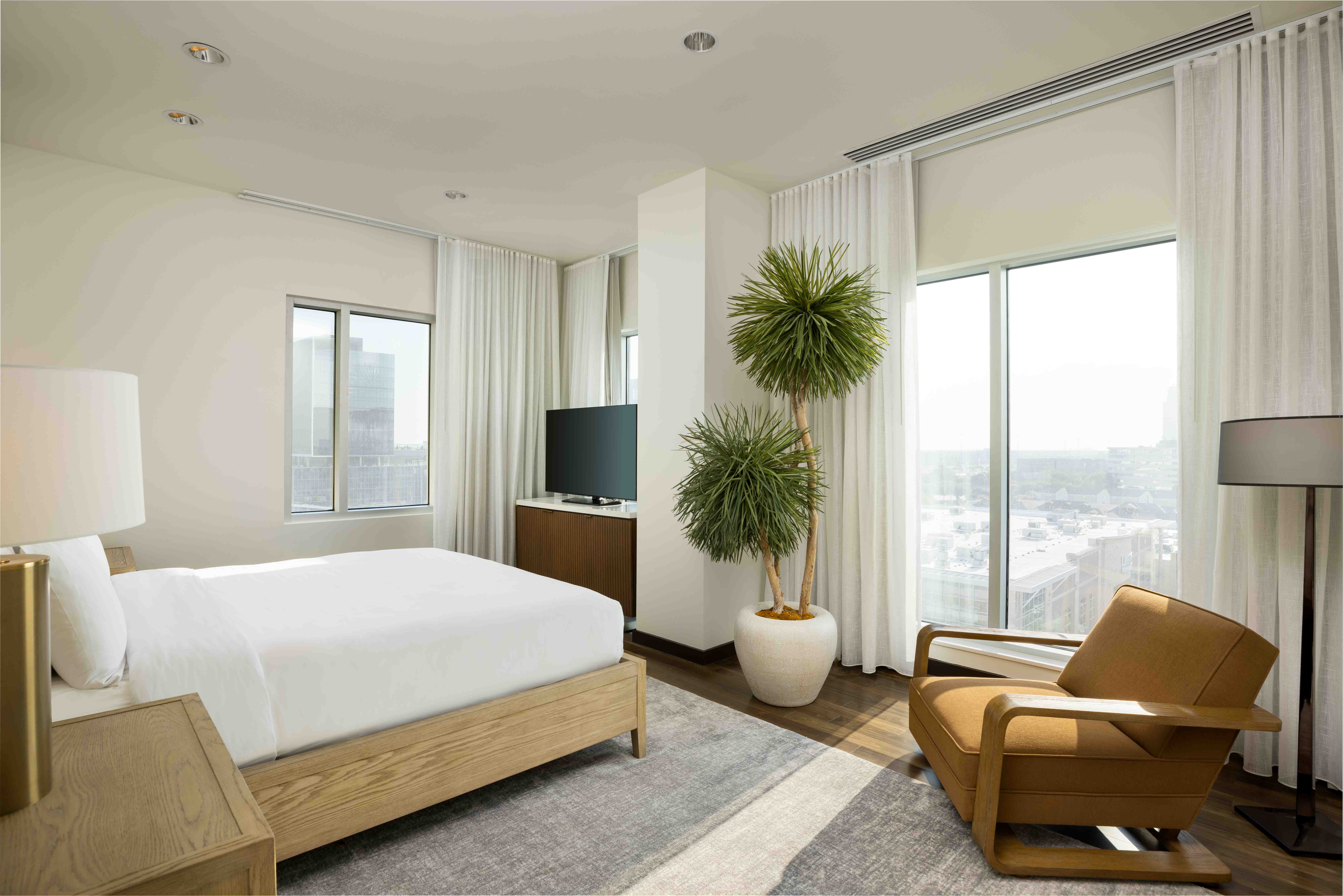 Hotel room with large bed and windows.