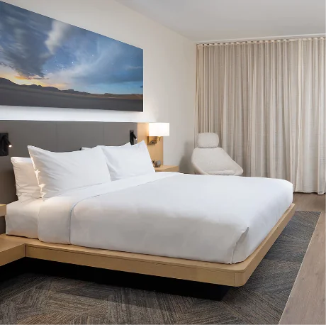 Hotel room with king bed and wall art.