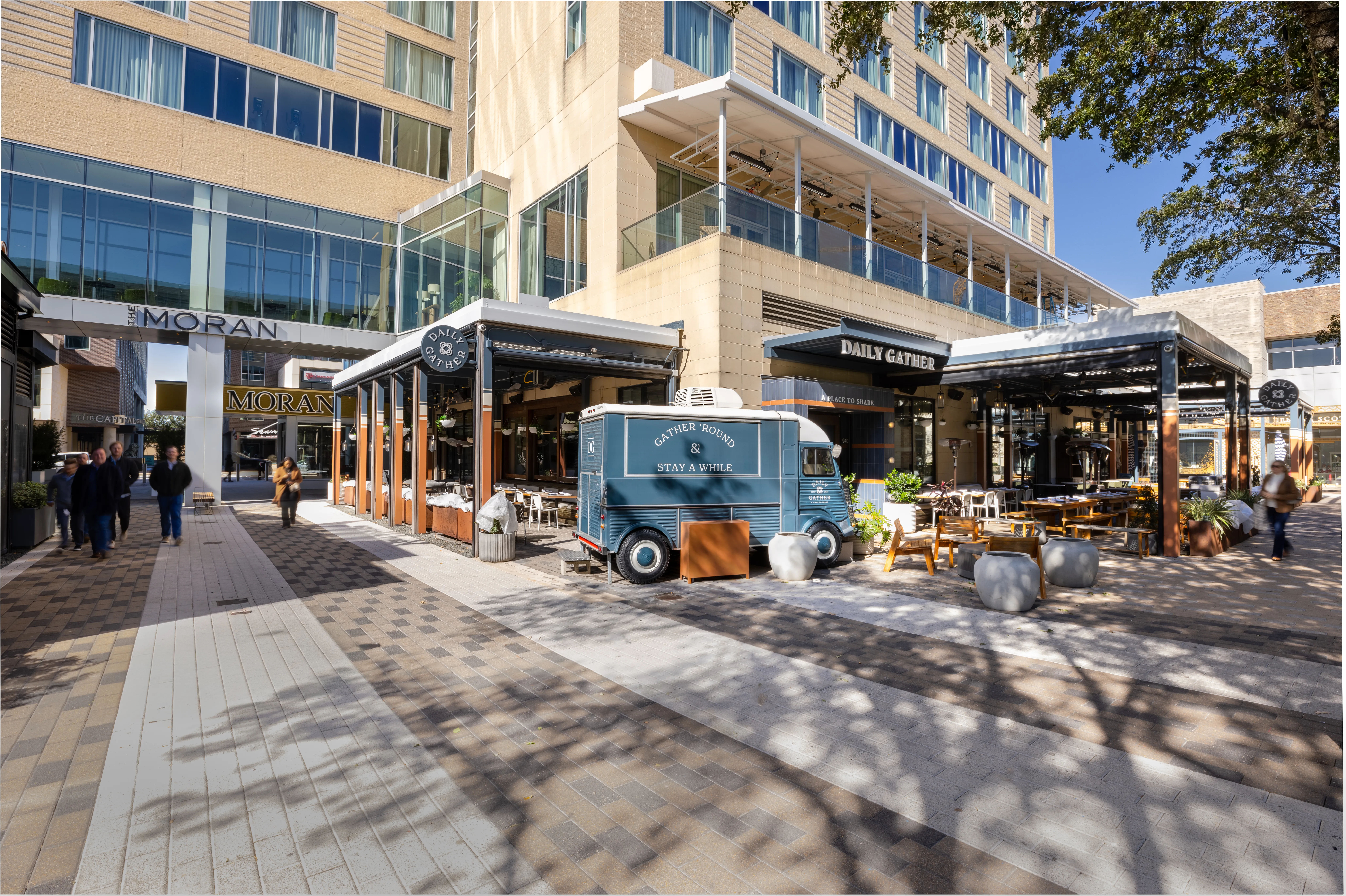 Outdoor dining area with a truck parked in front of the hotel.