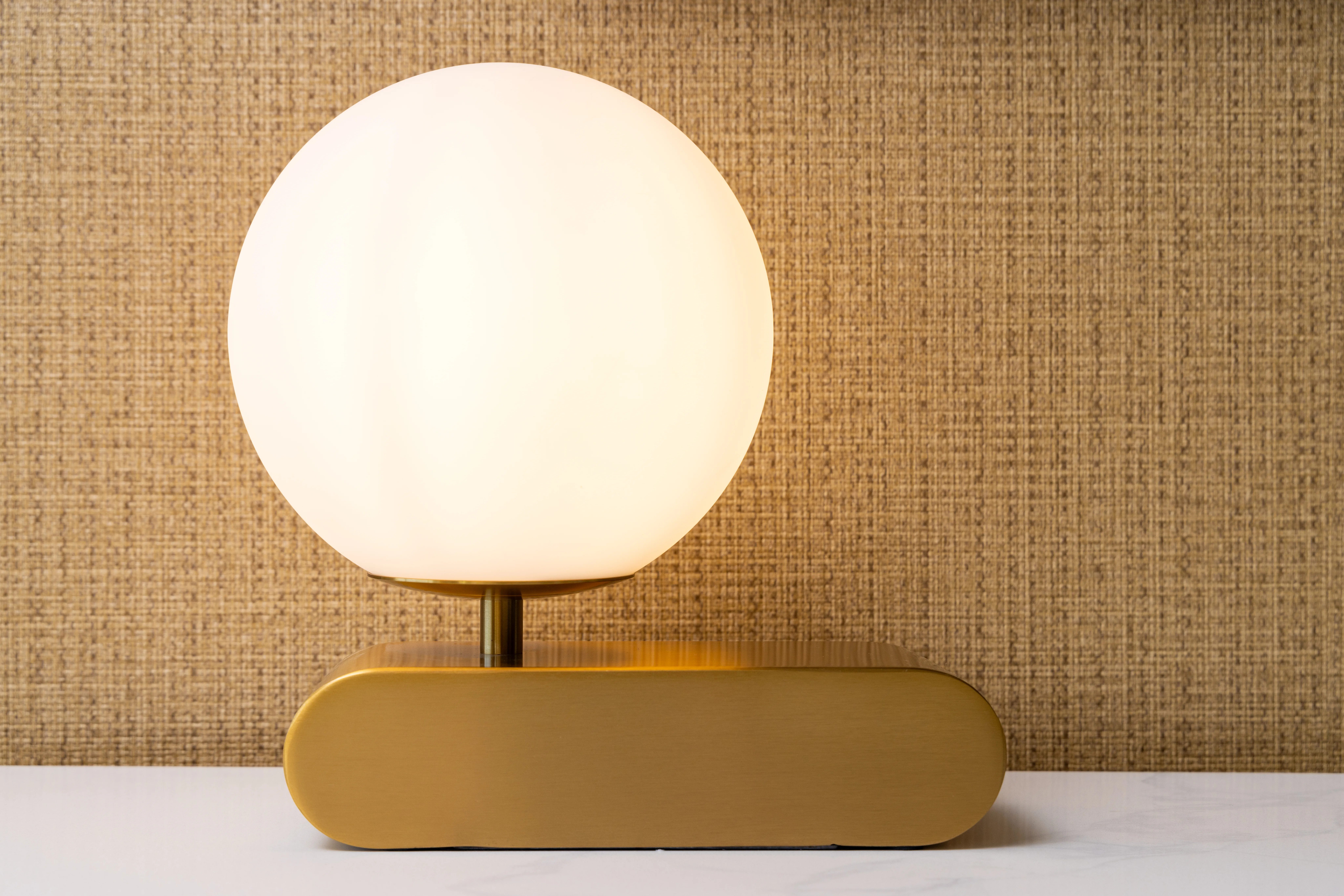 Round lamp on wooden nightstand.